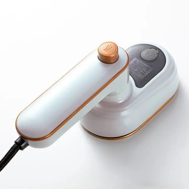 A compact handheld electric iron/garment steamer in white with rose-gold trim, shown with a power cord and a rounded base on a white background.
