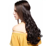 A woman with long, straight brown hair wearing a yellow off-shoulder top. One side of her hair is styled in loose waves, with a clip securing the rest of her hair in place.