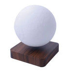 A minimalist moon-style lamp featuring a textured white spherical light mounted on a square wood-look base.