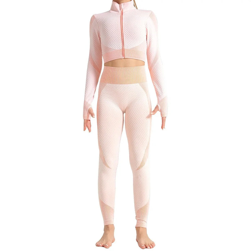 Woman wearing a seamless, textured long-sleeve athletic zip-up top in a light pink and peach gradient, featuring a high collar and thumb holes.