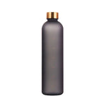Tall matte black reusable water bottle with a gold-colored screw-on lid and faint measurement markings down the front, on a white background