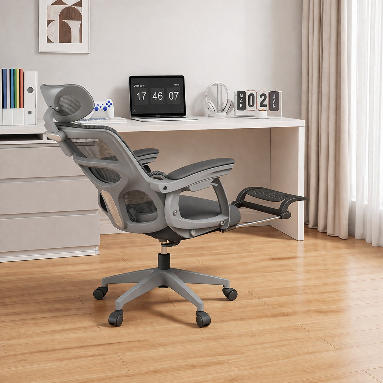 Grey office chair in front of a white desk with a laptop and decor items.