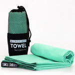 Microfiber towel set in a mesh bag with the towel rolled and folded, in light green.