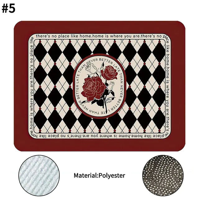 Rectangular polyester mat with a deep red border, black and cream diamond pattern, and a central circular rose motif, surrounded by the text “there’s no place like home,” with fabric texture close-up details shown.