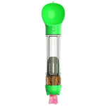 Green handheld pet treat dispenser with a clear tube showing kibble inside and a small pink strap at the bottom, on a white background.