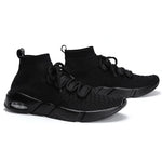 A pair of black knit high-top sneakers with laces, sock-like ankles, and chunky black soles with a small visible air cushion, shown on a white background.