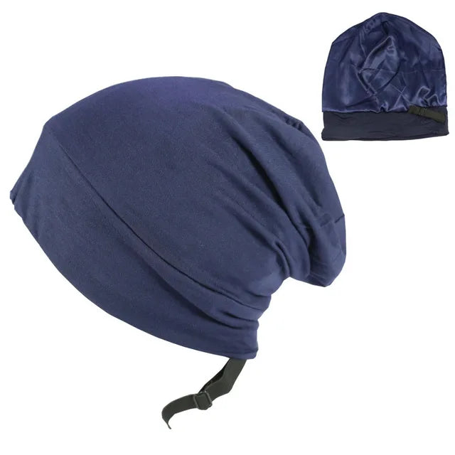 Navy blue satin sleep bonnet/head wrap with an adjustable strap, shown on a white background with a small inset image of the bonnet from another angle.