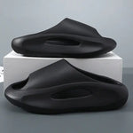 A pair of stylish black slip-on sandals with purple cushioned insoles, featuring cutout designs on the sides and toes, displayed on a white surface next to stacked books.