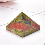 Green and red marble pyramid-shaped stone with visible cracks and variations in color.