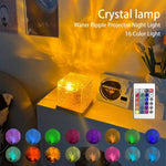 Crystal cube projector lamp casting a warm golden water-ripple light across a room, shown on a bedside table with a remote and multiple colour options.
