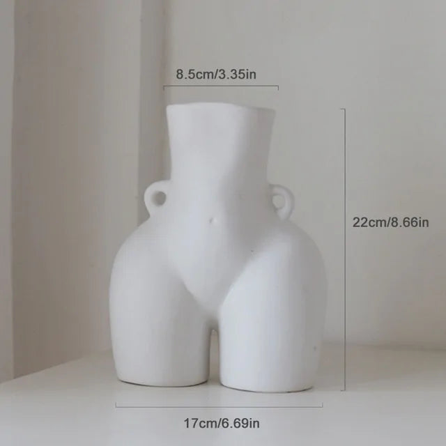A white ceramic vase shaped like a stylized female torso with small side handles, shown with measurement labels (about 22 cm tall and 17 cm wide) on a neutral background.