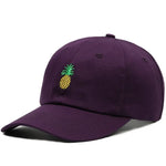 Dark purple baseball cap with a small embroidered yellow-and-green pineapple on the front, shown on a white background.