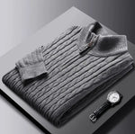 A neatly fold sweat shirt on a black surface with a black leather watch b the side