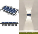 Solar-powered wall light with a rectangular solar panel and four LED lenses; image shows product dimensions and an example of the light casting up-and-down beams on an outdoor wall.