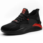 A black and dark gray athletic sneaker with a breathable knit upper, accented by bold orange wave-like stripes on the sides and orange detailing on the midsole. The shoe features a thick, textured sole and black-and-white patterned laces, designed for both style and performance.
