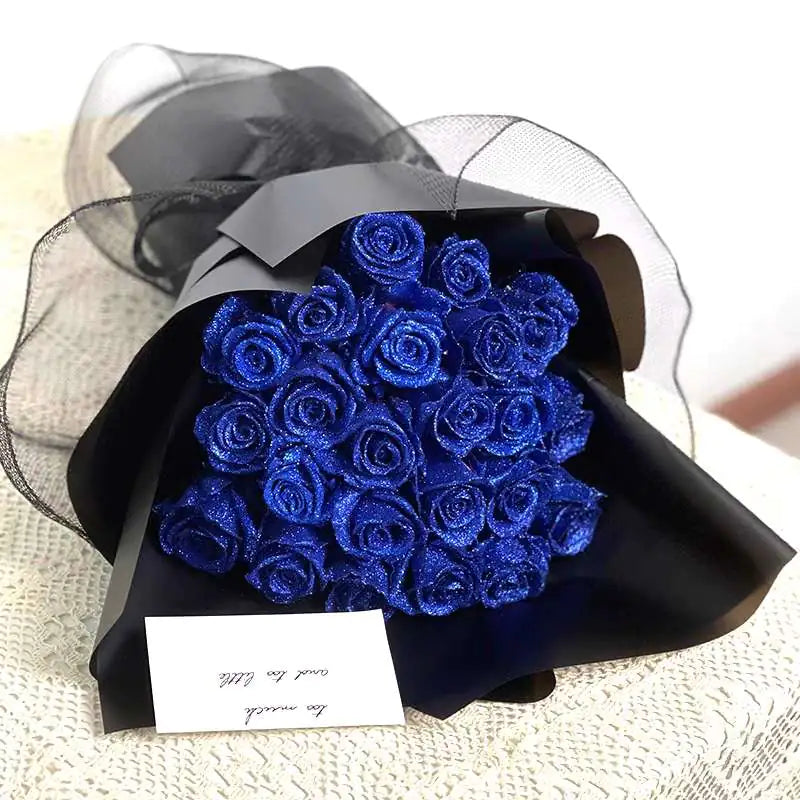Bouquet of glittery royal blue roses wrapped in black paper with a small note card attached.