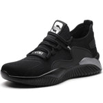A black and dark gray athletic sneaker with a breathable knit upper, accented by bold orange wave-like stripes on the sides and orange detailing on the midsole. The shoe features a thick, textured sole and black-and-white patterned laces, designed for both style and performance.