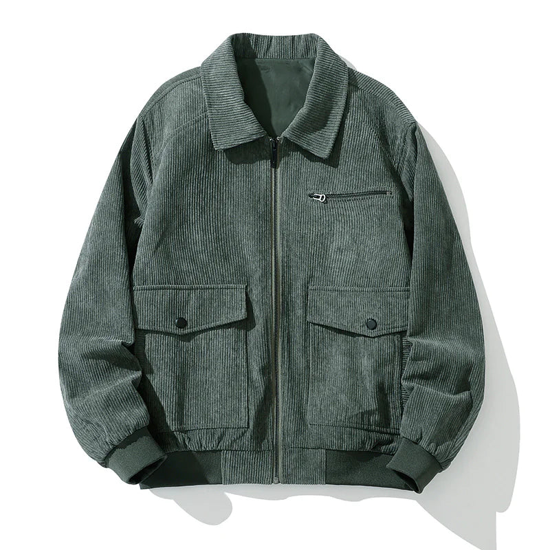 A vintage-style dark green corduroy jacket with a zip-up front, laid flat against a white background. The jacket features a classic collar, ribbed cuffs and hem, a zippered chest pocket, and two large flap pockets with button closures. The textured fabric gives it a stylish, retro-inspired look.