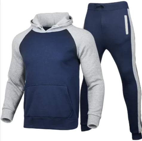 A stylish two-piece men's tracksuit. The set includes a hooded sweatshirt with a kangaroo pocket and long gray sleeves, along with matching jogger pants that have a drawstring waist and gray side panels with zippered pockets. The design offers a sporty yet casual look, ideal for workouts or everyday wear.