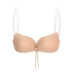 Brief alt text: Strapless nude adhesive bra with a lace-up front and clear detachable shoulder straps.