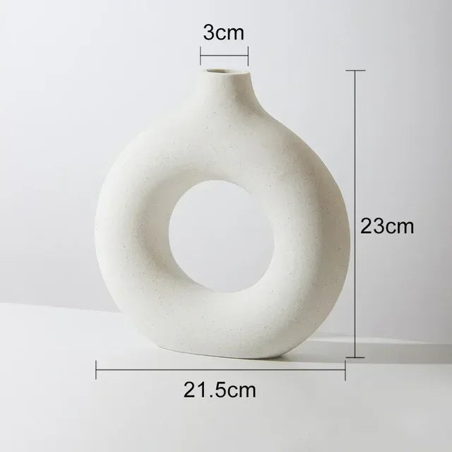 Matte off-white donut-shaped ceramic vase with a small neck, shown against a light background with dimensions labeled: 23 cm tall, 21.5 cm wide, and a 3 cm opening at the top.