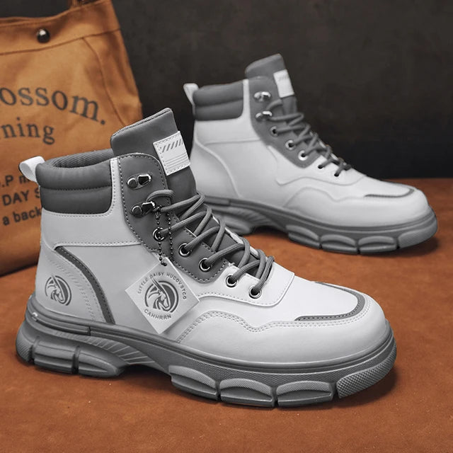 A pair of sleek black leather ankle boots with rugged rubber soles, lace-up fronts, and metal eyelets, displayed on a gray fabric surface with one boot propped up on a vintage-style book for presentation.