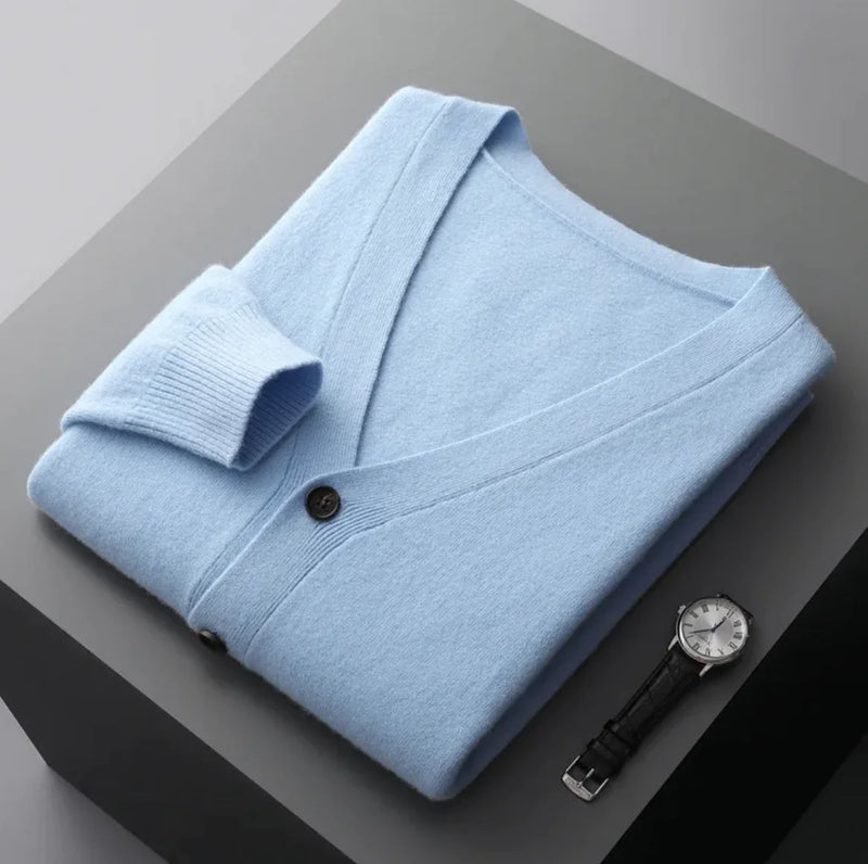 A neatly fold shirt on a black box with a black leather watch beside it