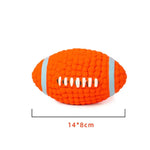 Orange textured rugby ball dog toy with white stripe details and stitched grip pattern, shown with a 14 × 8 cm size label.
