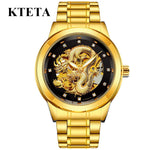 Gold KTETA wristwatch with a metal link band and a black dial featuring a gold dragon skeleton design and crystal hour markers, shown on a white background.