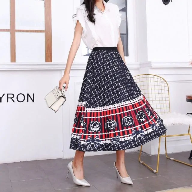 Pleated midi skirt with a gradient design, transitioning from dark black at the waistband to a soft blush pink at the hem, hanging on a black clothing rack next to a vintage-style camera.