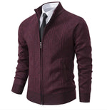 A stylish men's zip-up cardigan in a deep burgundy color with a subtle geometric pattern. The sweater features a ribbed collar, cuffs, and hem, and is worn over a white dress shirt with a black tie, giving it a formal yet modern look.