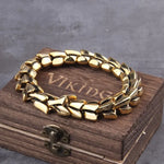 Gold-toned chunky chain bracelet with wide polished links, displayed on a wooden box labeled “Viking” against a gray background.