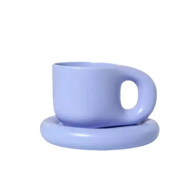Light lavender ceramic cup with a rounded handle, resting on a matching saucer against a white background.