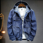 A stylish denim jacket with a hood, layered over a white graphic t-shirt and accessorized with a silver pendant necklace. The jacket features a button-up front, multiple pockets, and a slightly distressed finish, giving it a rugged yet fashionable look. The hoodie detail adds a modern, casual touch, making it perfect for streetwear or casual outings.