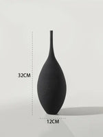 A matte black decorative vase with a tall narrow neck and rounded teardrop-shaped body. The image includes size markings showing the vase is approximately 32 cm tall and 12 cm wide.