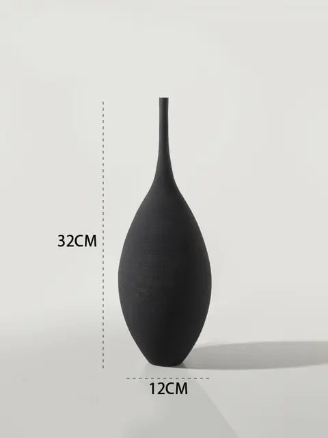 A matte black decorative vase with a tall narrow neck and rounded teardrop-shaped body. The image includes size markings showing the vase is approximately 32 cm tall and 12 cm wide.