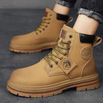 A pair of tan high-top boots with a thick jute-wrapped sole and colorful teddy bear patchwork fabric on the sides. The boots have a rugged design with metal eyelets and a branded patch on the side, displayed against a warm brown background.