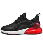 A black and dark gray athletic sneaker with a breathable knit upper, accented by bold orange wave-like stripes on the sides and orange detailing on the midsole. The shoe features a thick, textured sole and black-and-white patterned laces, designed for both style and performance.