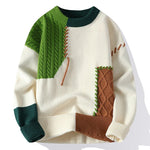 A patchwork-style sweater with an off-white base, featuring contrasting green, brown, and dark green ribbed knit textures. The design includes cable knit sections in green and brown, decorative stitching details, and ribbed cuffs, collar, and hem, creating a bold and modern aesthetic.