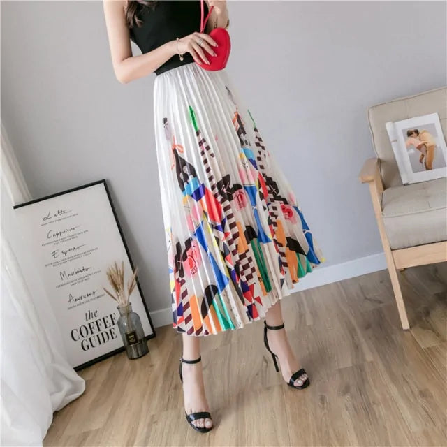 Pleated midi skirt with a gradient design, transitioning from dark black at the waistband to a soft blush pink at the hem, hanging on a black clothing rack next to a vintage-style camera.