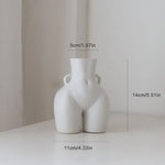 White abstract female body vase with small side handles, 14 cm height, 11 cm width, and 5 cm opening.