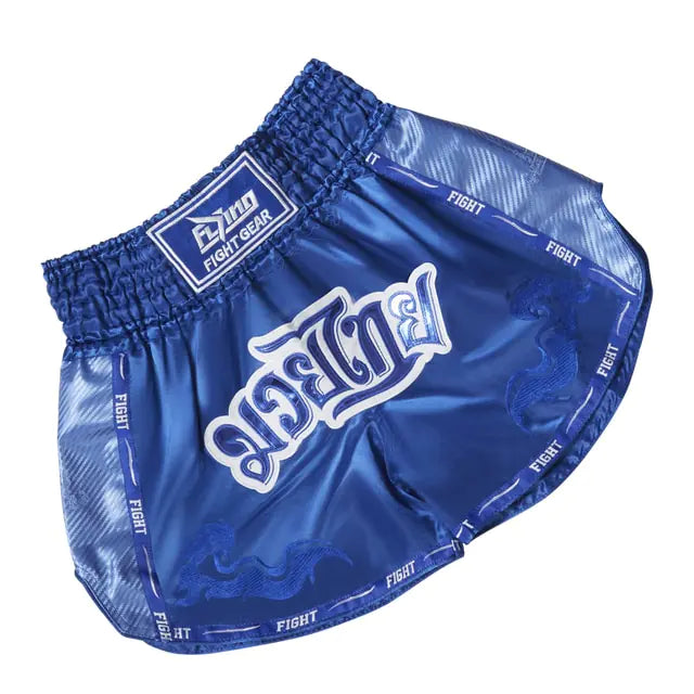 Blue satin Muay Thai-style boxing shorts with an elastic waistband, white “FIGHT” lettering across the front, and “FIGHT” trim around the edges on a white background.