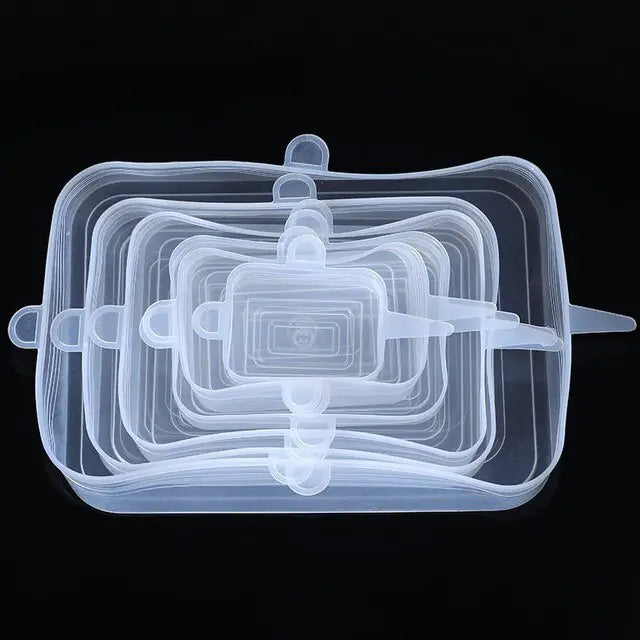 Set of clear rectangular silicone stretch lids in multiple sizes, stacked on a black background, with small pull tabs on the sides.