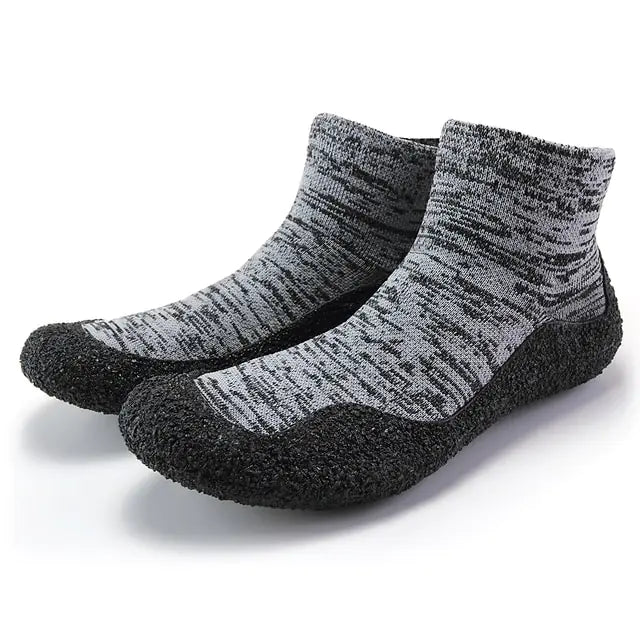 Grey and black barefoot water shoes with sock-style ankle cuffs and textured grip soles.