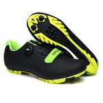 A pair of vibrant cycling shoes with a black and neon yellow camouflage pattern. The shoes feature a rugged sole with cleats, suitable for mountain biking or off-road cycling. They have two Velcro straps and a buckle fastening system for a secure fit. One shoe is placed upright while the other rests on its side, displaying the cleated sole.