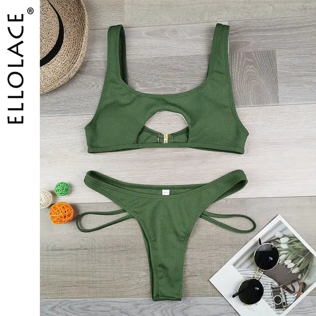 Olive-green ribbed bikini set laid flat on a wooden floor, featuring a scoop-neck top with a front cutout and buckle detail, and matching high-cut bottoms with side ties; “ELLOLACE” text along the side.