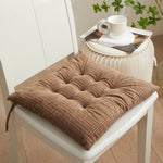 Brown textured cushion on a white chair with a table in the background