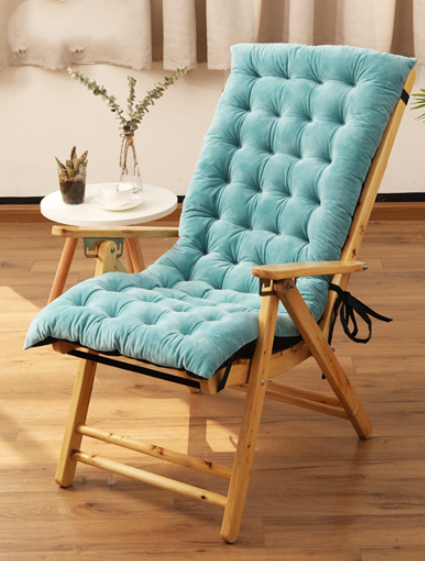 Chair with a blue cushion on a wooden floor, with a side table and plants in the background.
