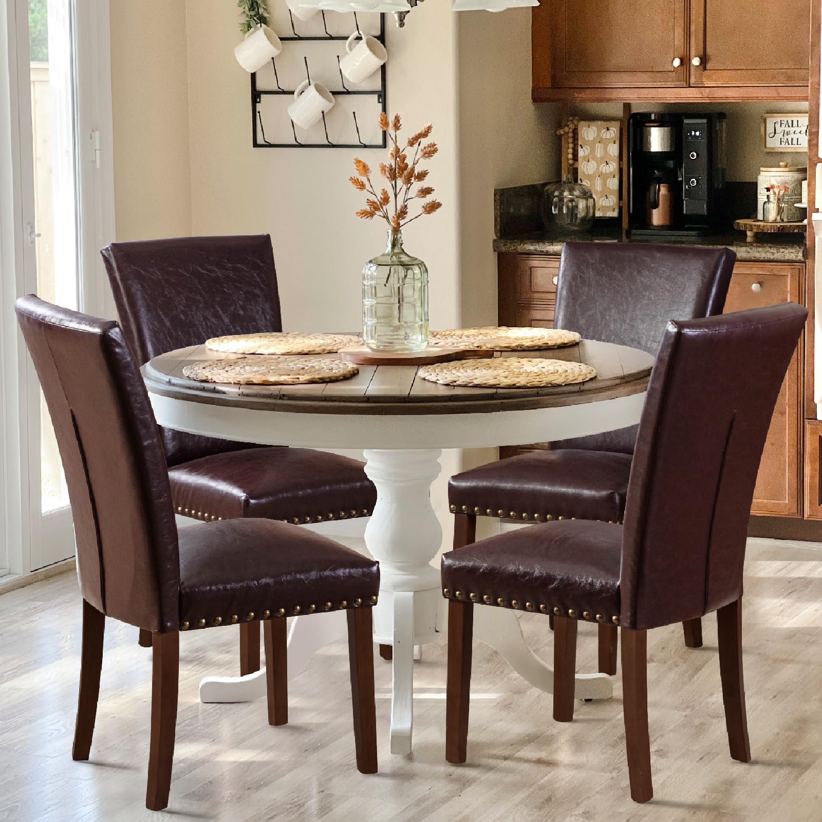 Dining room with a round table and four brown leather chairs.