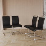 Four black chairs with metal legs on a wooden floor.